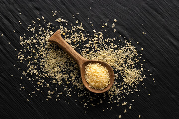 Crunchy yellow panko bread crumbs in wooden spoon.