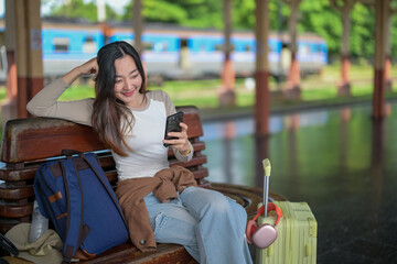 A woman sitting on a bench with a backpack and a suitcase