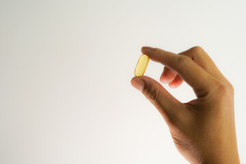 Male hand holding soft gels, Fish oil capsules, omega 3, omega 9, vitamin D, vitamin E, supplements