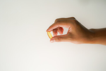Male hand holding soft gels, Fish oil capsules, omega 3, omega 9, vitamin D, vitamin E, supplements