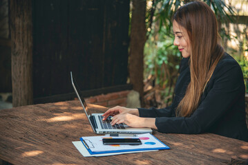 Happiness Asian Woman working from home using laptop online meeting in home office. Happy relax...