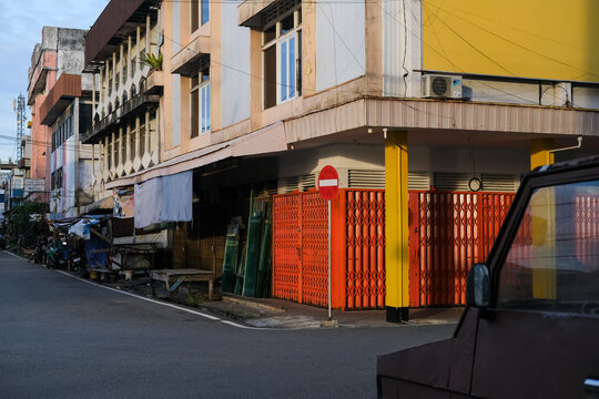 Old shop houses line a quiet street in the central market district of Pontianak, showcasing aging storefronts and the nostalgic charm of a traditional trading hub.