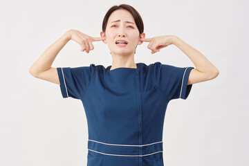 女性　美容看護師　耳を塞ぐ　白背景