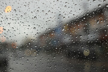 rain in the city blur background, water drop on windshield of car