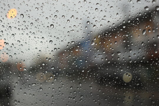 rain in the city blur background, water drop on windshield of car