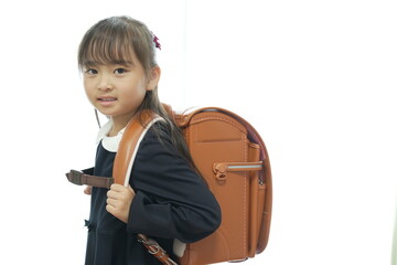 新一年生の女の子がランドセルを背負って登校する様子