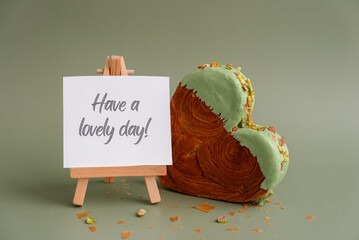 HAVE A LOVELY DAY text caption card Delicious fresh croissant topped with Matcha Green Tea flavor...