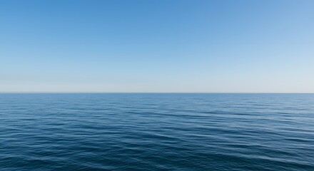 Obraz premium Serene ocean expanse under a clear, cloudless blue sky, showcasing tranquil waters.