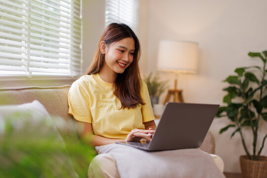Happy young asian woman or Happy Asian teen girl with her laptop apps, shopping online, reading news, browsing internet at home sitting on sofa
- Powered by Adobe