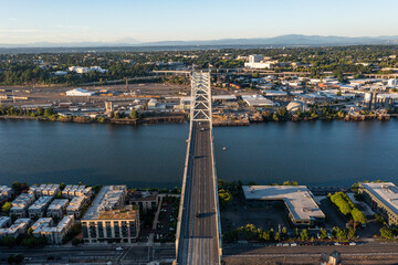 Obraz premium Aerial drone picture of Portland’s Fremont Bridge at sunset, the Willamette River, Downtown Portland, industrial area, and Mt. Hood in the background, with clear blue summer sky