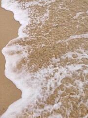 White Transparent Foam Of Waves on the Beach