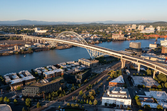 Aerial drone picture of Portland’s Fremont Bridge at sunset, the Willamette River, Downtown Portland, industrial area, and Mt. Hood in the background, with clear blue summer sky