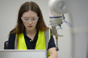Caucasian engineer woman working on AI technology in robotics electronics engineering laboratory. University students' research project is programming robot machine with intelligent mechanical control