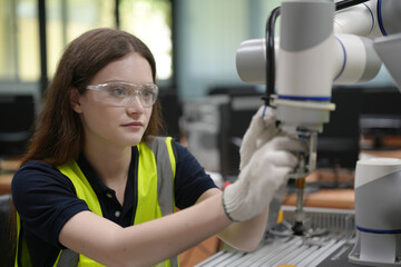 Caucasian engineer woman working on AI technology in robotics electronics engineering laboratory. University students' research project is programming robot machine with intelligent mechanical control