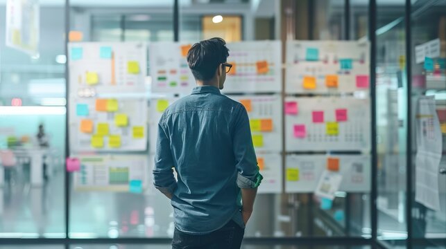 A project manager reviewing agile workflow charts and kanban boards to ensure smooth project execution.