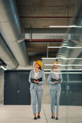 Female engineer inspecting ventilation system in modern building