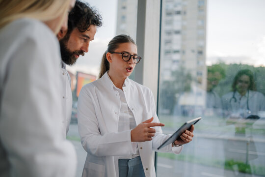 Medical team analyzing data on tablet for patient treatment strategy