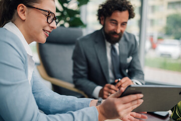 Businesswoman showing tablet to businessman during meeting