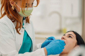 Dentist examining patient's teeth in dental clinic