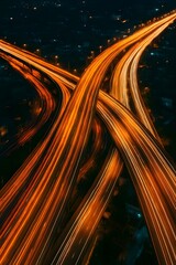 Aerial view of illuminated highway light trails at night, showcasing dynamic movement and urban landscape. Perfect for concepts of speed, transportation, and modern infrastructure