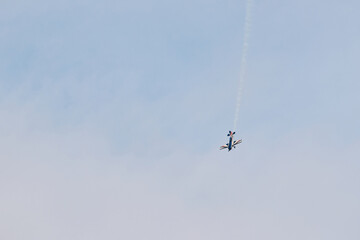Aerobatic Airplane Performing Smoke Maneuver in Blue Sky