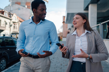 Business colleagues walking and talking on city street