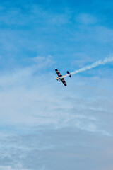Aerobatic Airplane Performing Smoke Maneuver in Blue Sky