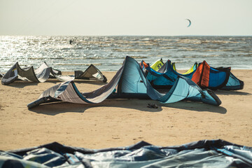 Kite surfing at beach by sea with colorful inflatable kites waiting for competition. Surfers...