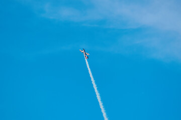 Aerobatic Airplane Performing Smoke Maneuver in Blue Sky
