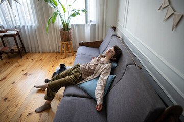 Lethargic woman lying still in lazy pose, mental fatigue and disinterest in daily life with pet....