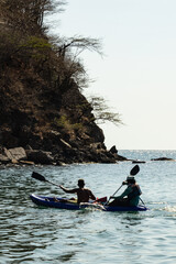 two mans kayaking in a caribean beach 