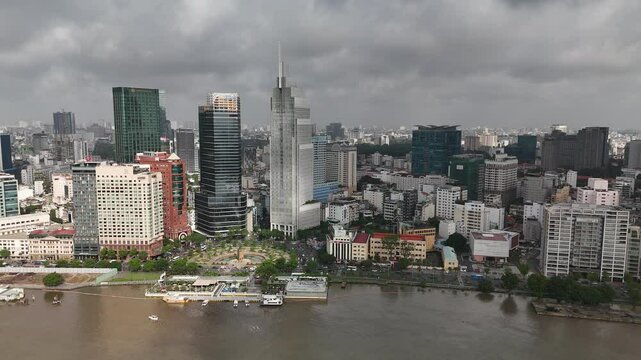 Ho Chi Minh City, Vietnam: 4K Aerial Drone Footage of Downtown Skyline, Vietcombank Tower, Saigon River, Ba Son Bridge, Roundabout and Busy Traffic on a Cloudy Day in Southeast Asia Vibrant Urban