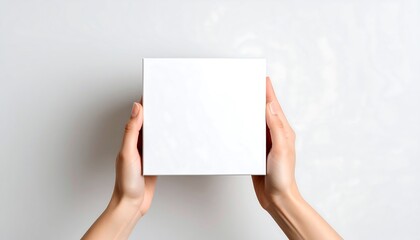 Obraz premium Hands holding a blank white square box