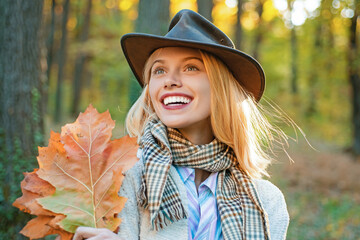 Autumn face of happy young woman. Smiling girl on autumn fall background. Beauty girl with fall...