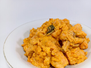 A plate of Chicken Salted Egg, a rich, creamy, and flavorful dish, presented against a plain white...