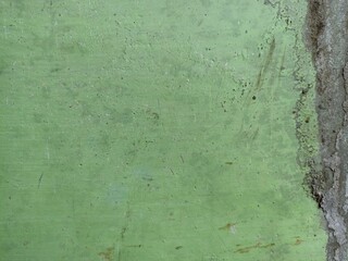 Old Green Wall with Cracks and Peeling Edge. Textured green painted wall with subtle cracks, stains, and peeling on the right edge. Perfect for vintage or grunge-style backgrounds