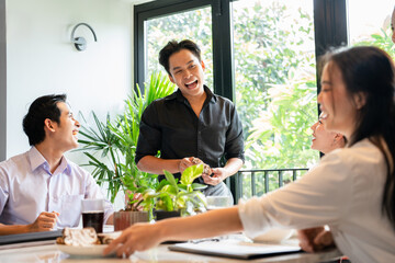 Group of  businesspeople in office, enjoying a coffee break and engaging in friendly conversation,...