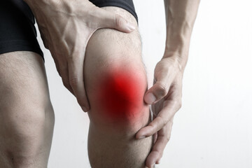 man with knee pain, he puts his hand on his knee, pain point from osteoarthritis and...