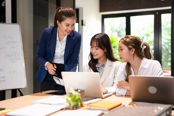 Focused female intern listening to senior  business woman mentor teacher explaining online strategy...