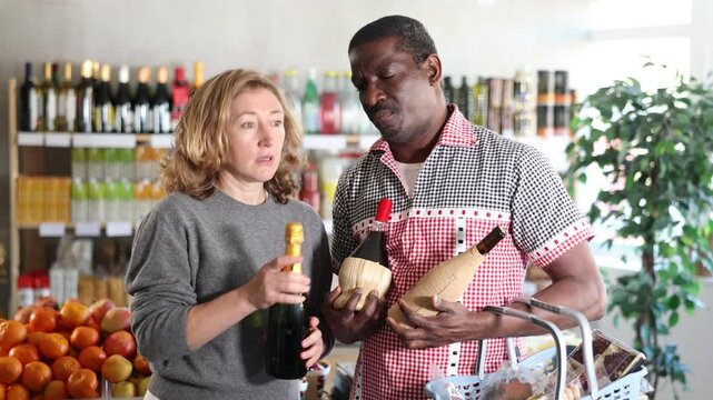 Married couple choose wine together for a holiday party at a grocery store. High quality 4k footage - Powered by Adobe