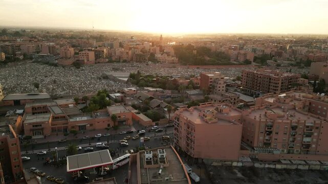 Aerial panoramic view of Marrakech city at sunrise with soft morning light illuminating terracotta buildings and streets in Morocco