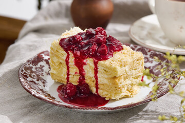 Napoleon cake slice with cherry compote, bright natural light, closeup table composition