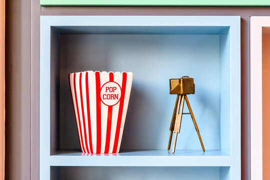 Popcorn bag and retro camera tripod model decorations on a display shelf