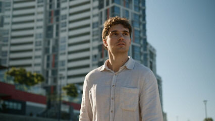 Obraz premium Young Caucasian European man male guy walking going stroll street city outside businessman worker employee entrepreneur student tourist looking around go pensive thinking business building walk urban
