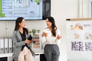 two designer in office, enjoying a coffee break and engaging in friendly conversation, fostering...