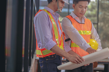Structural engineer and architect and foreman worker with blueprints discuss, plan working for the building construction site office. Construction collaboration concept