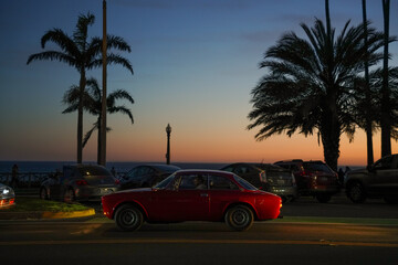 red car on the night beach sunset 