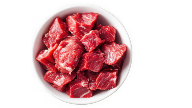 Overhead shot of a white bowl brimming with raw, cubed beef, showcasing its texture