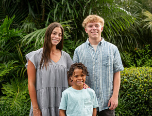 Casual Portrait of a diverse group of beautiful children. Cute smiling faces of hispanic girl, African American boy and caucasian boy.