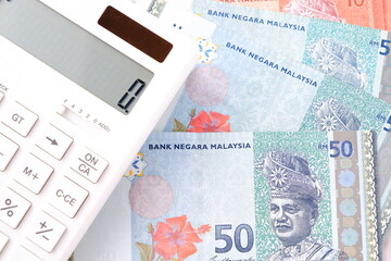 マレーシアの通貨、リンギット（MYR）の紙幣と、白い電卓	

